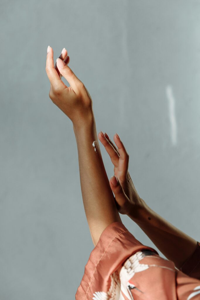 Close-up of moisturized hands applying cream in natural light. Perfect for skincare and beauty themes.